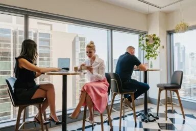 Clients enjoying Servcorp’s casual coworking lounge with stunning city views.