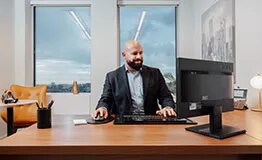 Businessman in a serviced office at 10 Avenue Kléber, enjoying premium workspace, city views, and professional amenities.